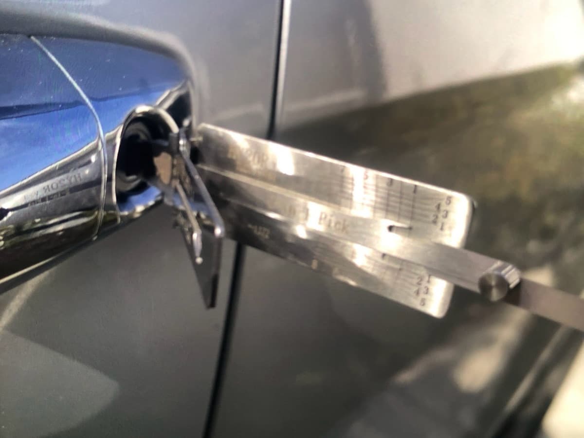 A locksmith’s pick-and-decoder tool in a car door lock